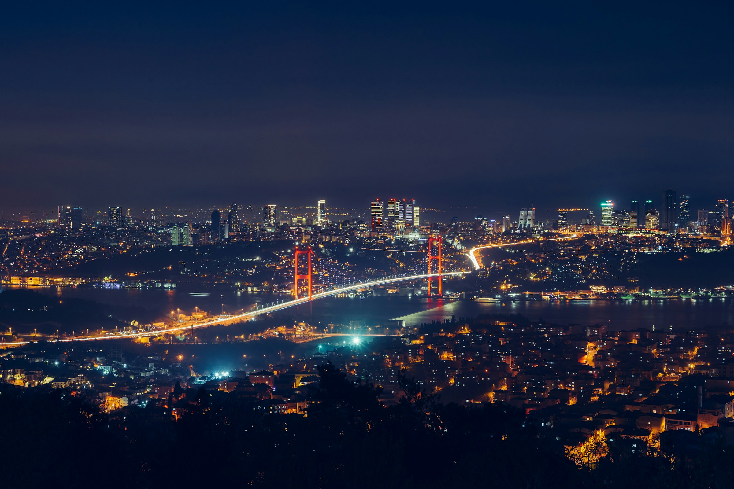 Aerial night view of Istanbul's Bosphorus Bridge lit in neon lights